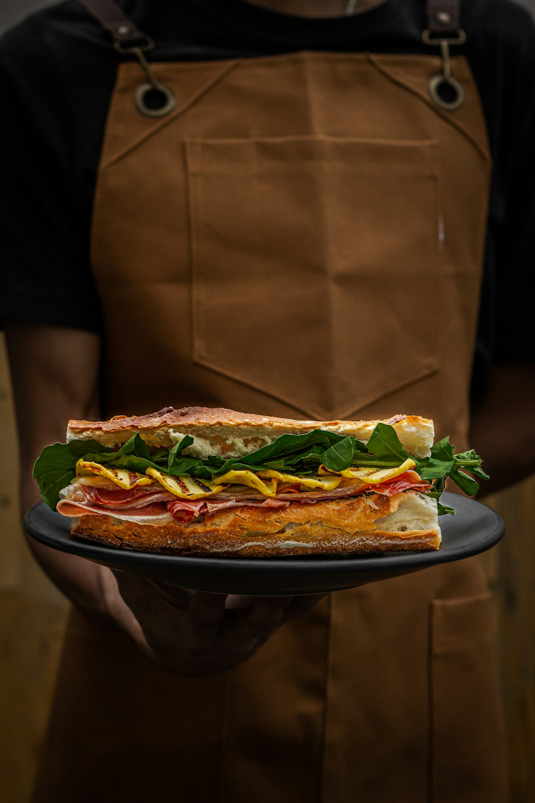 a-person-holding-a-plate-with-a-sandwich-on-it-urxejykwc18