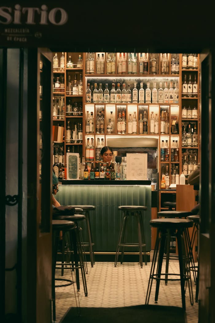 Warm interior of a bar in Puebla, showcasing a fully stocked liquor shelf and inviting ambiance.