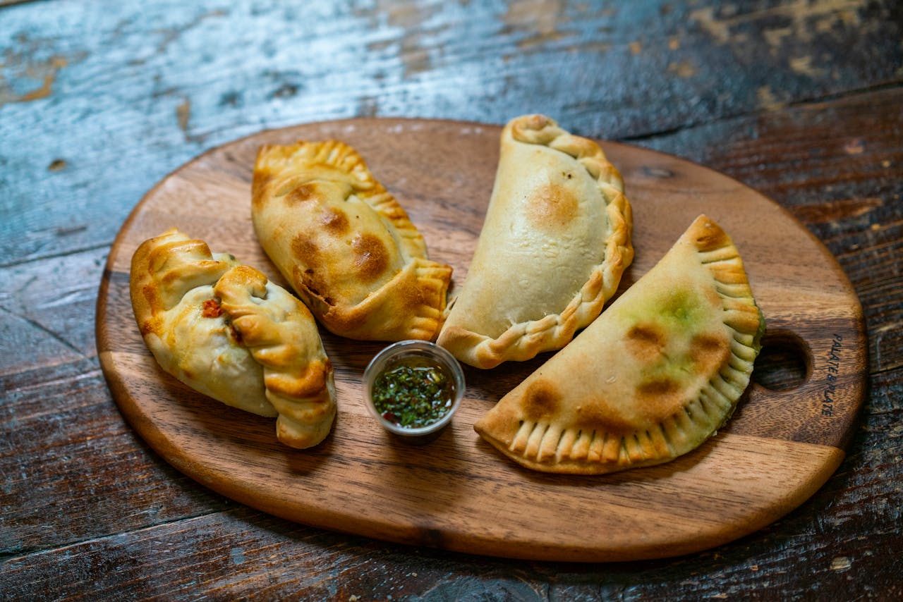 about-03 Tasty baked empanadas on a wooden board with dip, perfect for authentic cuisine lovers.