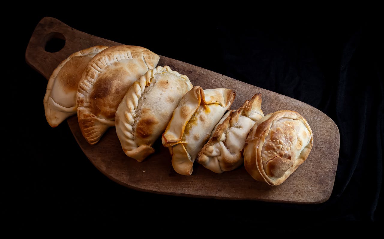 about-02 Delicious homemade empanadas on a wooden board, showcasing traditional Argentine cuisine.